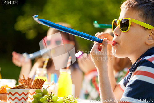 Image of kids blowing party horns on birthday in summer