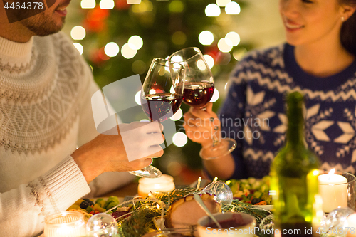 Image of happy couple drinking red wine at christmas dinner