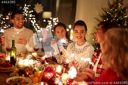 Image of happy friends celebrating christmas at home feast