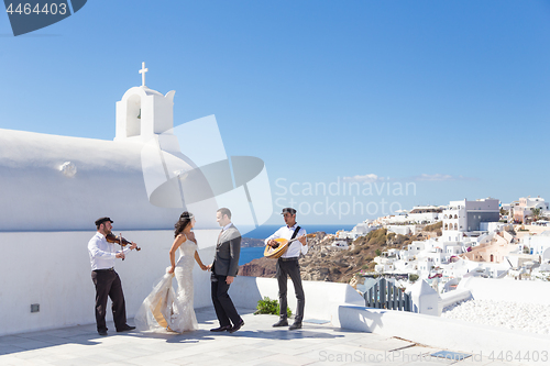 Image of Bride and groom dansing on wedding ceremony on Santorini island, Greece.