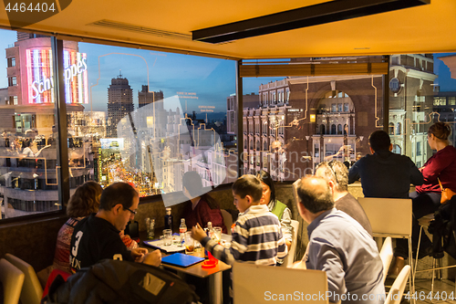 Image of People enjoying evening drinks and amazing panoramic views of Madrid at dusk on rooftop bar of El Corte Ingles department store in Madrid, Spain.