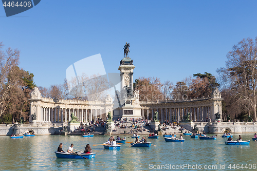 Image of Tourists rowing traditional blue boats on lake in Retiro city park on a nice sunny winter day in Madrid, Spain.