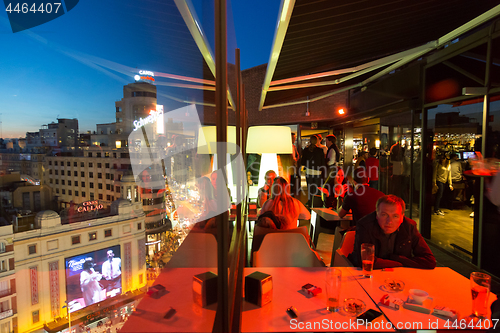 Image of People enjoying evening drinks and amazing panoramic views of Madrid at dusk on rooftop bar of El Corte Ingles department store in Madrid, Spain.