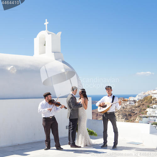 Image of Bride and groom dansing on wedding ceremony on Santorini island, Greece.