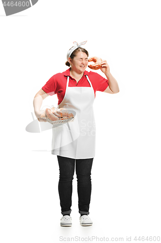 Image of Portrait of cute smiling woman with pastries in her hands in the studio, isolated on white background