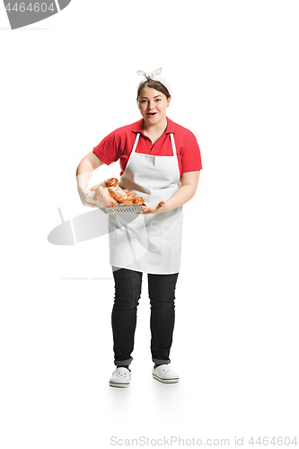 Image of Portrait of cute smiling woman with pastries in her hands in the studio, isolated on white background