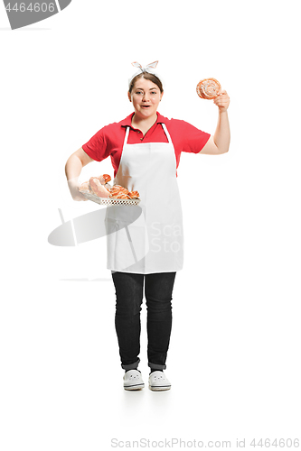 Image of Portrait of cute smiling woman with pastries in her hands in the studio, isolated on white background