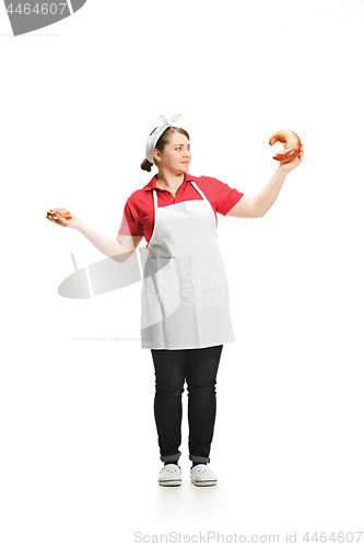 Image of Portrait of cute smiling woman with pastries in her hands in the studio, isolated on white background