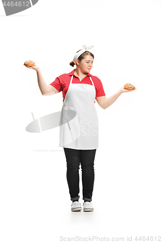 Image of Portrait of cute smiling woman with pastries in her hands in the studio, isolated on white background