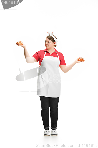 Image of Portrait of cute smiling woman with pastries in her hands in the studio, isolated on white background