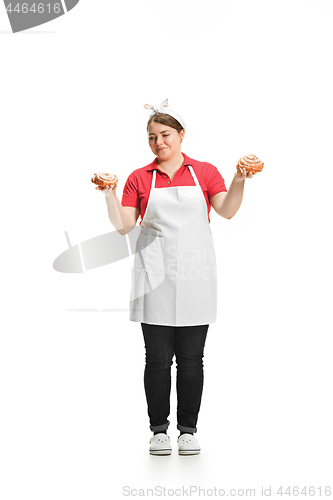 Image of Portrait of cute smiling woman with pastries in her hands in the studio, isolated on white background