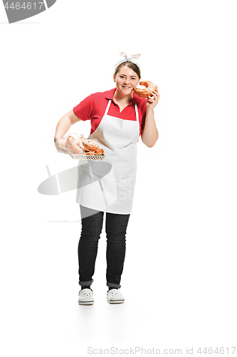 Image of Portrait of cute smiling woman with pastries in her hands in the studio, isolated on white background