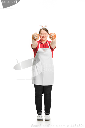 Image of Portrait of cute smiling woman with pastries in her hands in the studio, isolated on white background