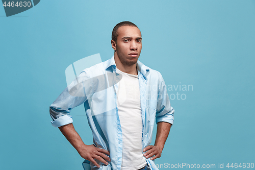 Image of The serious businessman standing and looking at camera against studio background.