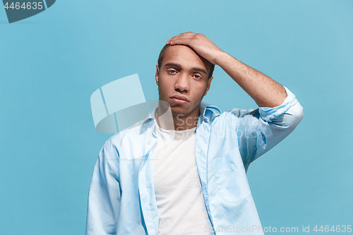 Image of Man having headache. Isolated over blue background.