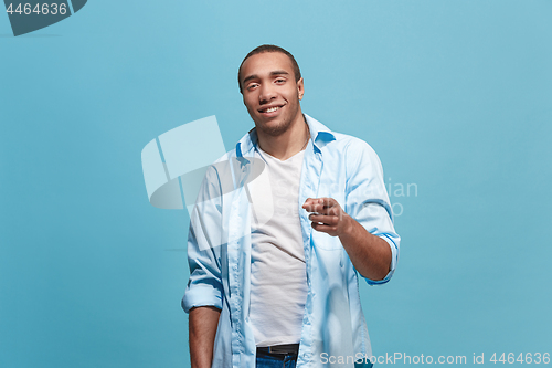 Image of The happy business man point you and want you, half length closeup portrait on blue background.