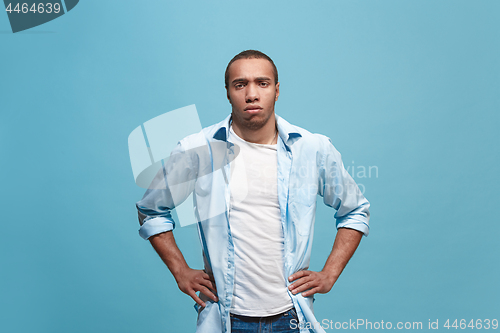 Image of The serious businessman standing and looking at camera against studio background.