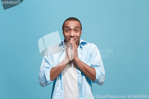 Image of The young attractive man looking suprised isolated on blue