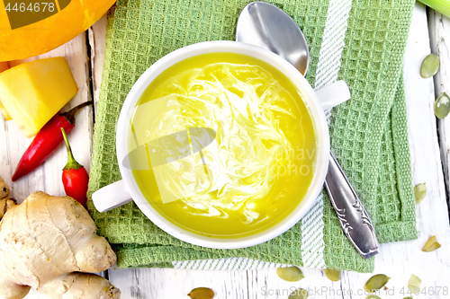 Image of Soup-puree pumpkin with cream in white bowl on green napkin top