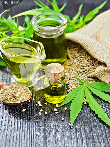 Image of Oil hemp in two jars and sauceboat on black board