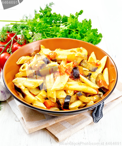 Image of Pasta penne with eggplant and tomatoes on light board