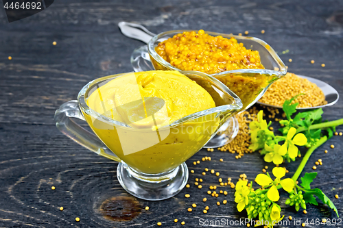 Image of Sauce mustard in two sauceboats with flower on black board