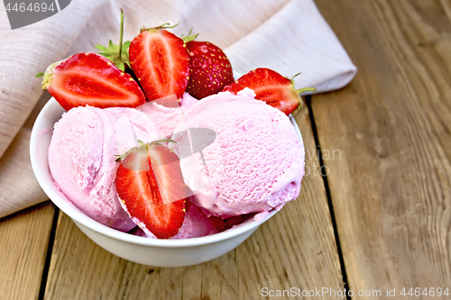 Image of Ice cream strawberry in bowl on wooden board