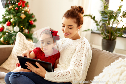 Image of mother and daughter with tablet pc on christmas