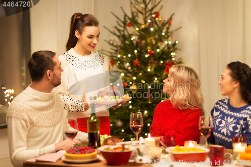 Image of happy friends having christmas dinner at home