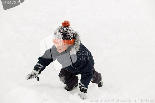 Image of happy little boy in winter clothes outdoors