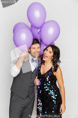 Image of happy couple with ultra violet balloons at party