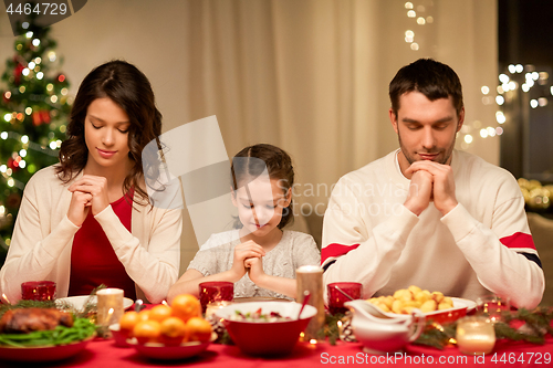 Image of family praying before meal at christmas dinner