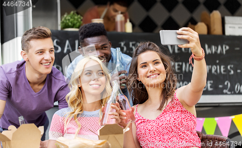 Image of happy young friends taking selfie at food truck