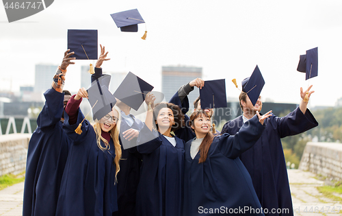 Image of happy graduates or students throwing mortar boards