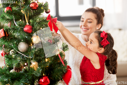 Image of happy family decorating christmas tree at home