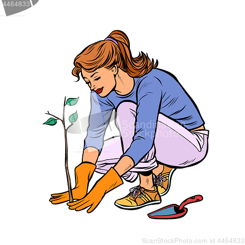 Image of woman working in the garden, planting a seedling