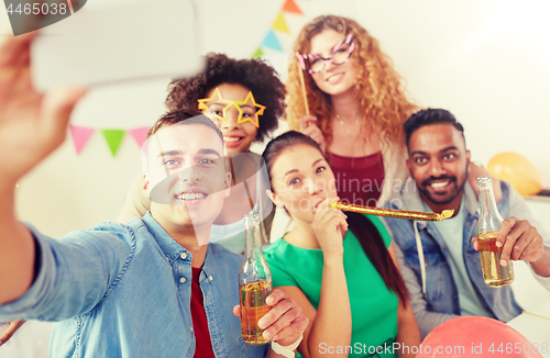 Image of happy team taking selfie at office party