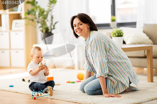 Image of happy mother with little baby son playing at home