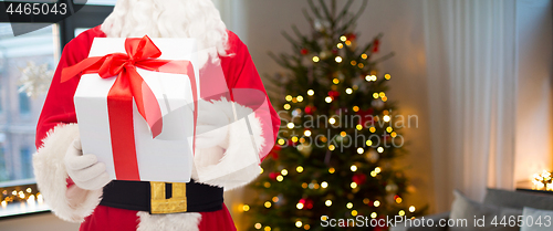 Image of santa claus with christmas gift over room