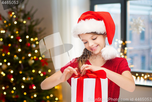 Image of happy girl with christmas gift at home