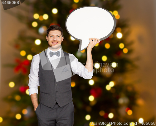 Image of man holding blank text bubble over christmas tree