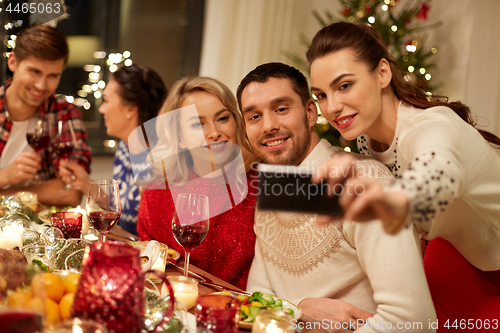 Image of friends having christmas dinner and taking selfie