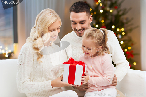 Image of happy family at home with christmas gift