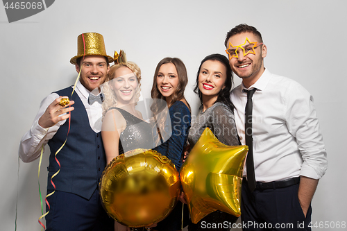 Image of happy friends with golden party props posing