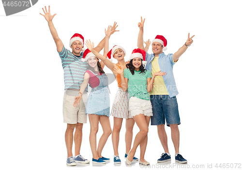 Image of happy friends in santa hats over white background