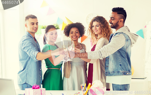 Image of happy team with champagne at office birthday party