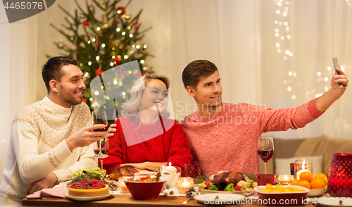 Image of friends taking selfie at christmas dinner