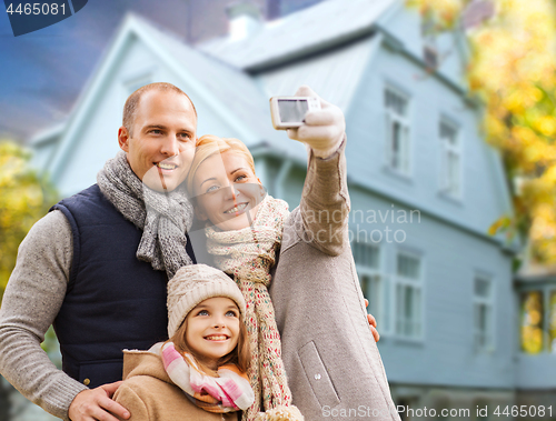 Image of family takes autumn selfie by cellphone over house