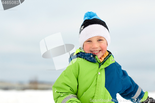 Image of happy little boy in winter clothes outdoors