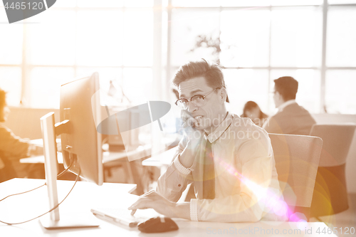 Image of Young businessman using computer at work